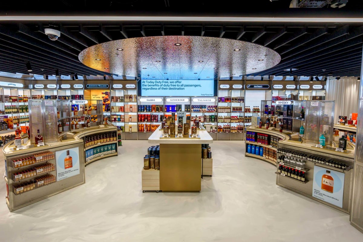 Duty-free retail shelves stocked with beverages and bonded-store products
