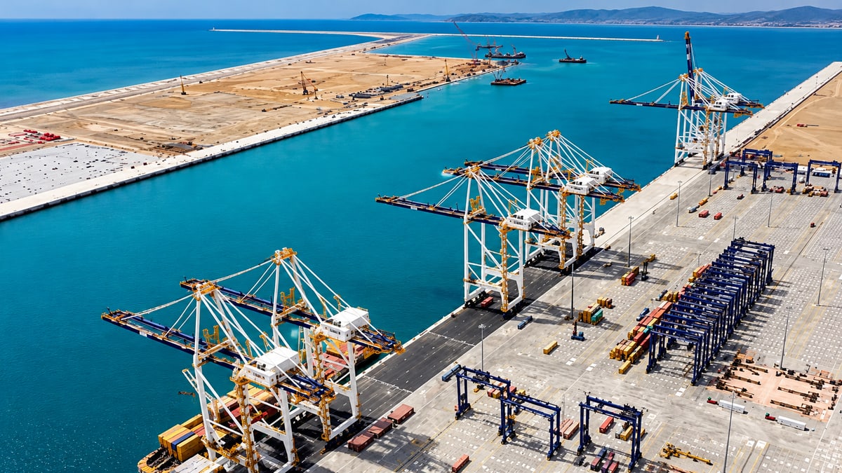 Aerial view of a commercial port with container cranes and cargo terminals